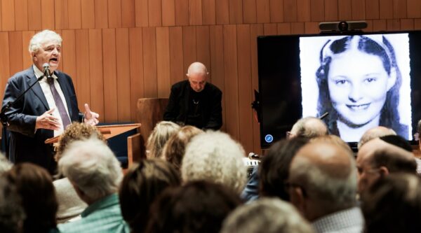 Dr Samuel Kassow speaking to audience with slide image of Josima Feldschuh in background.